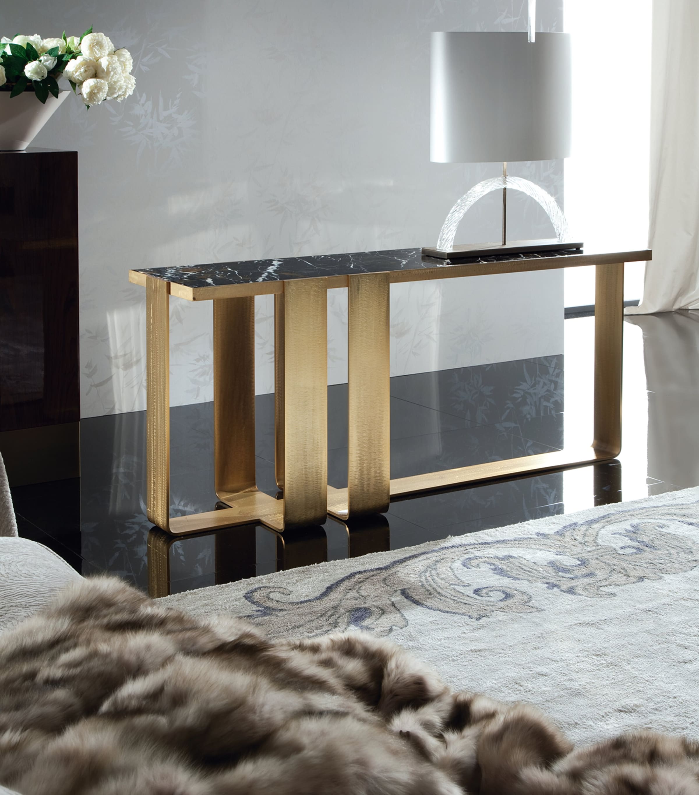 Gold-tone console table viewed from side with lamp on top
