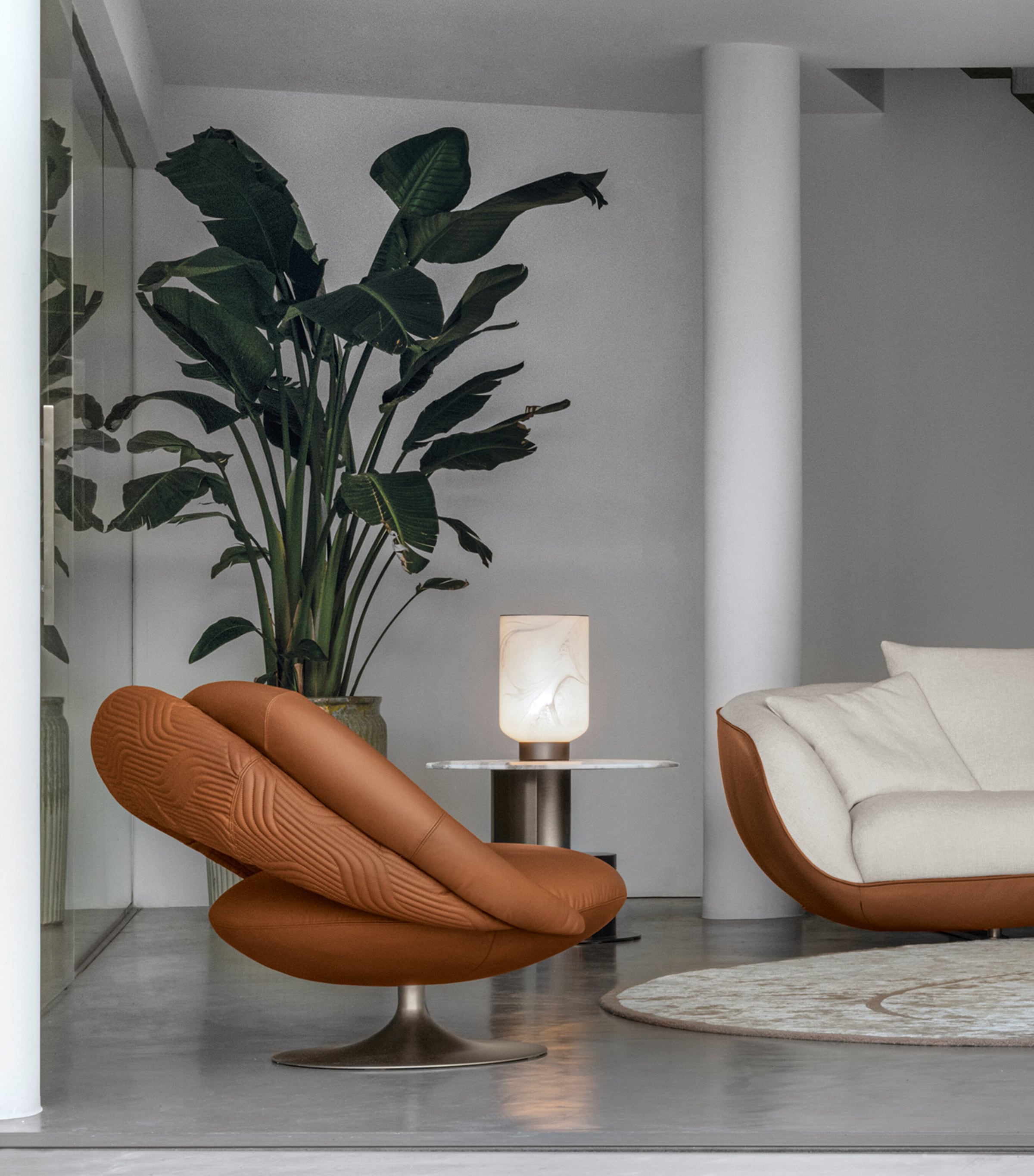 Brown leather lounge chair beside a sofa in a stylish living room