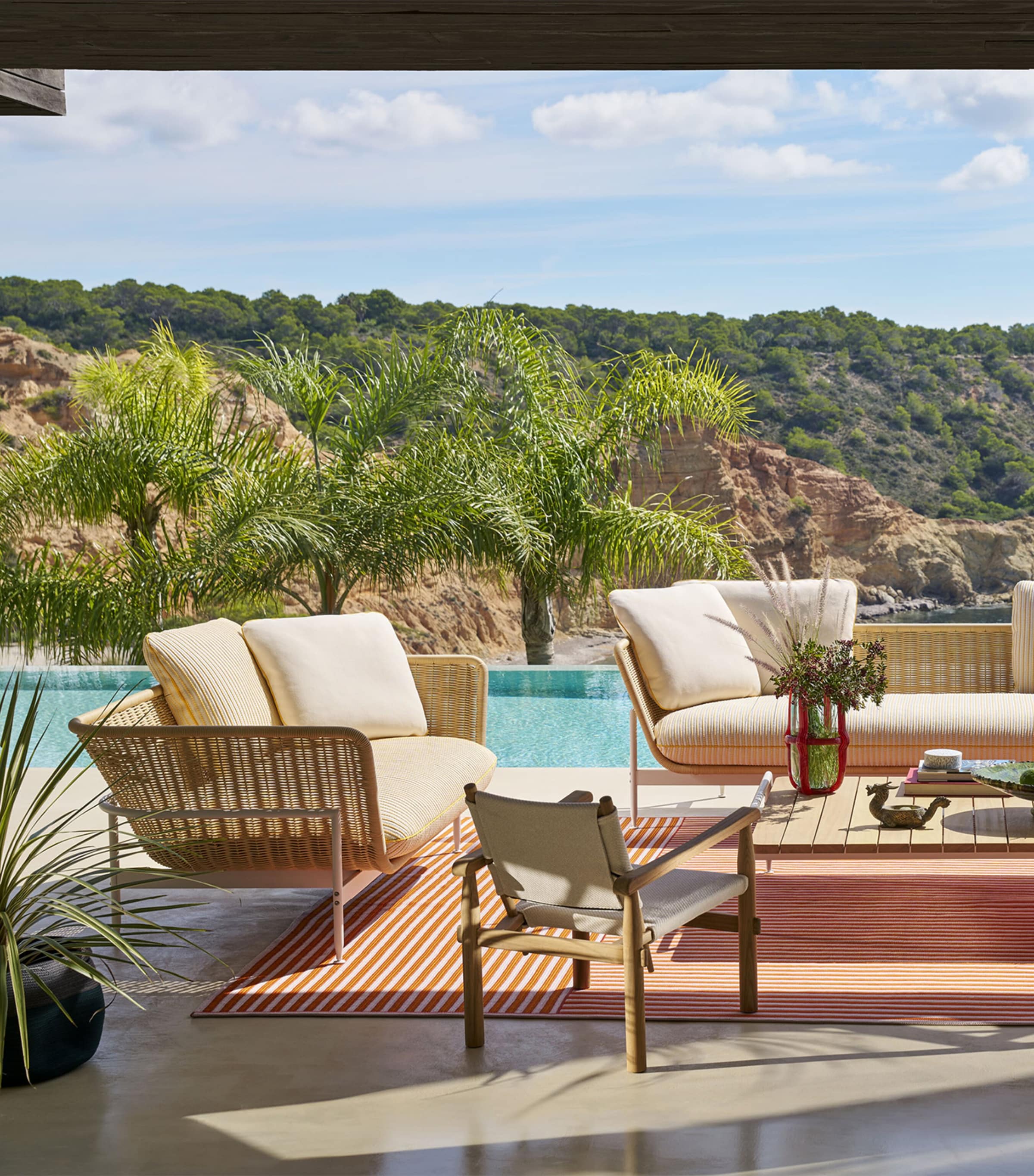 Outdoor patio with sofa set and palm plants by pool