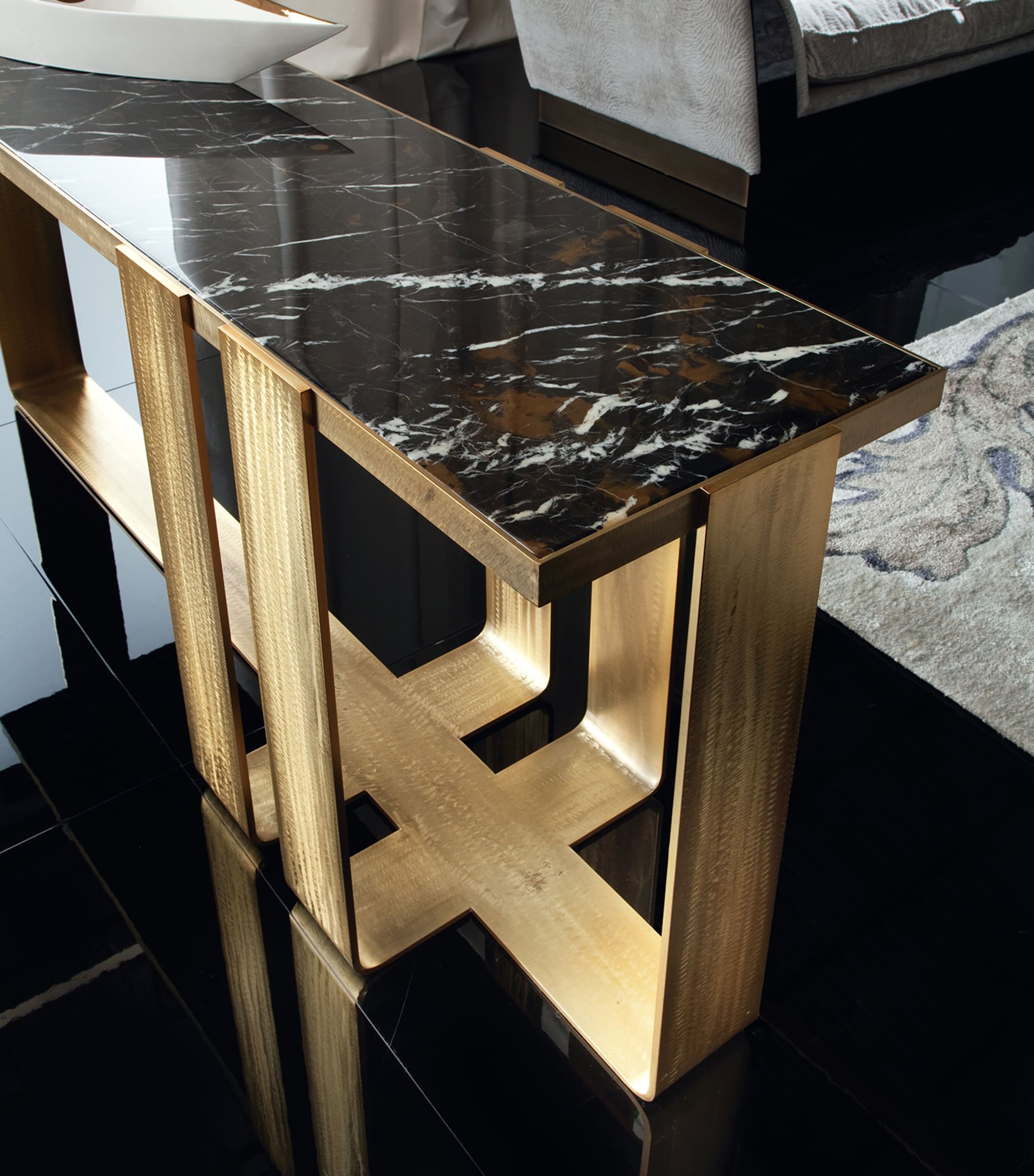 Close-up of black marble top and gold frame of console table