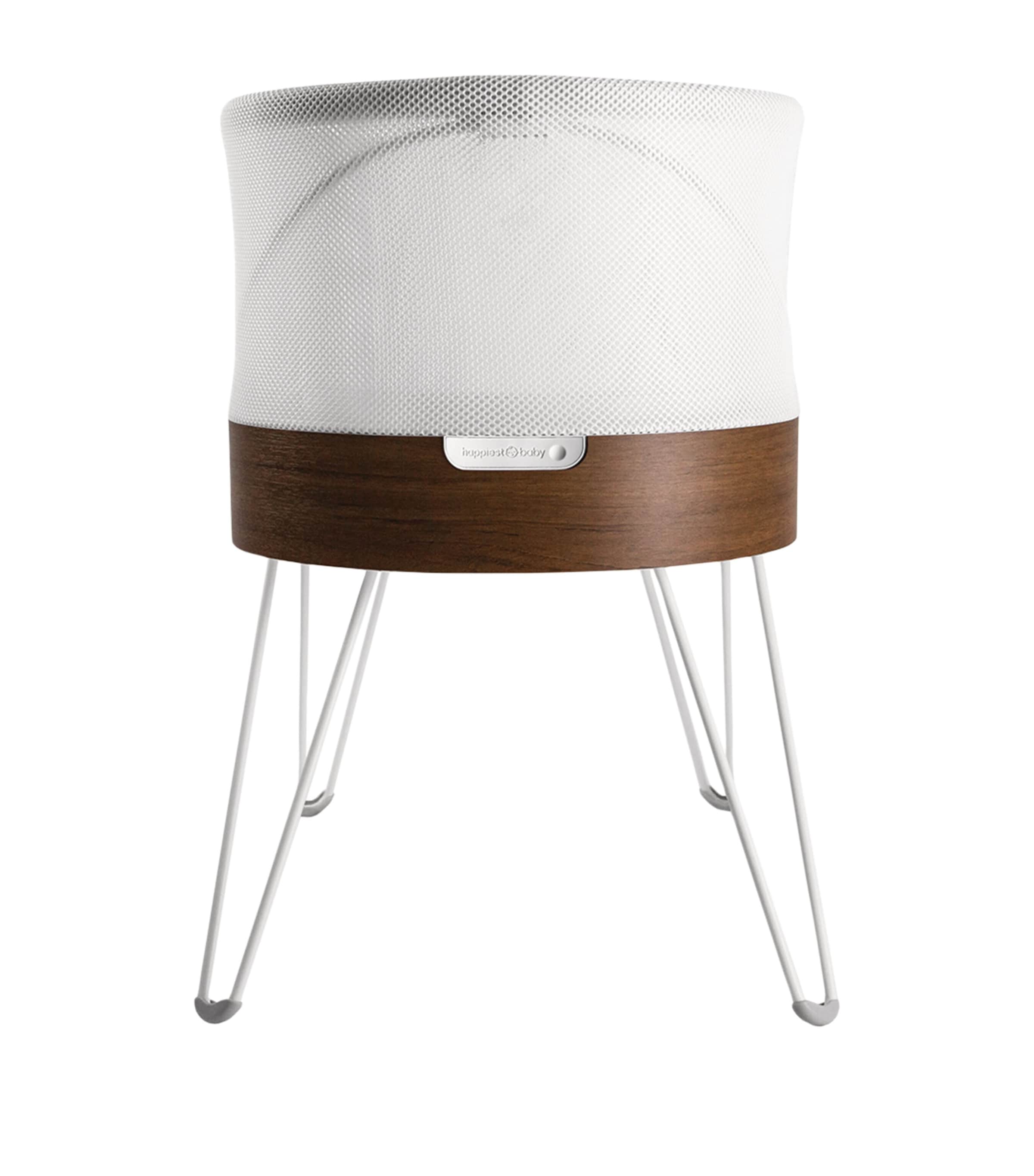 Front view of white textured baby cot with wooden base and white metal legs