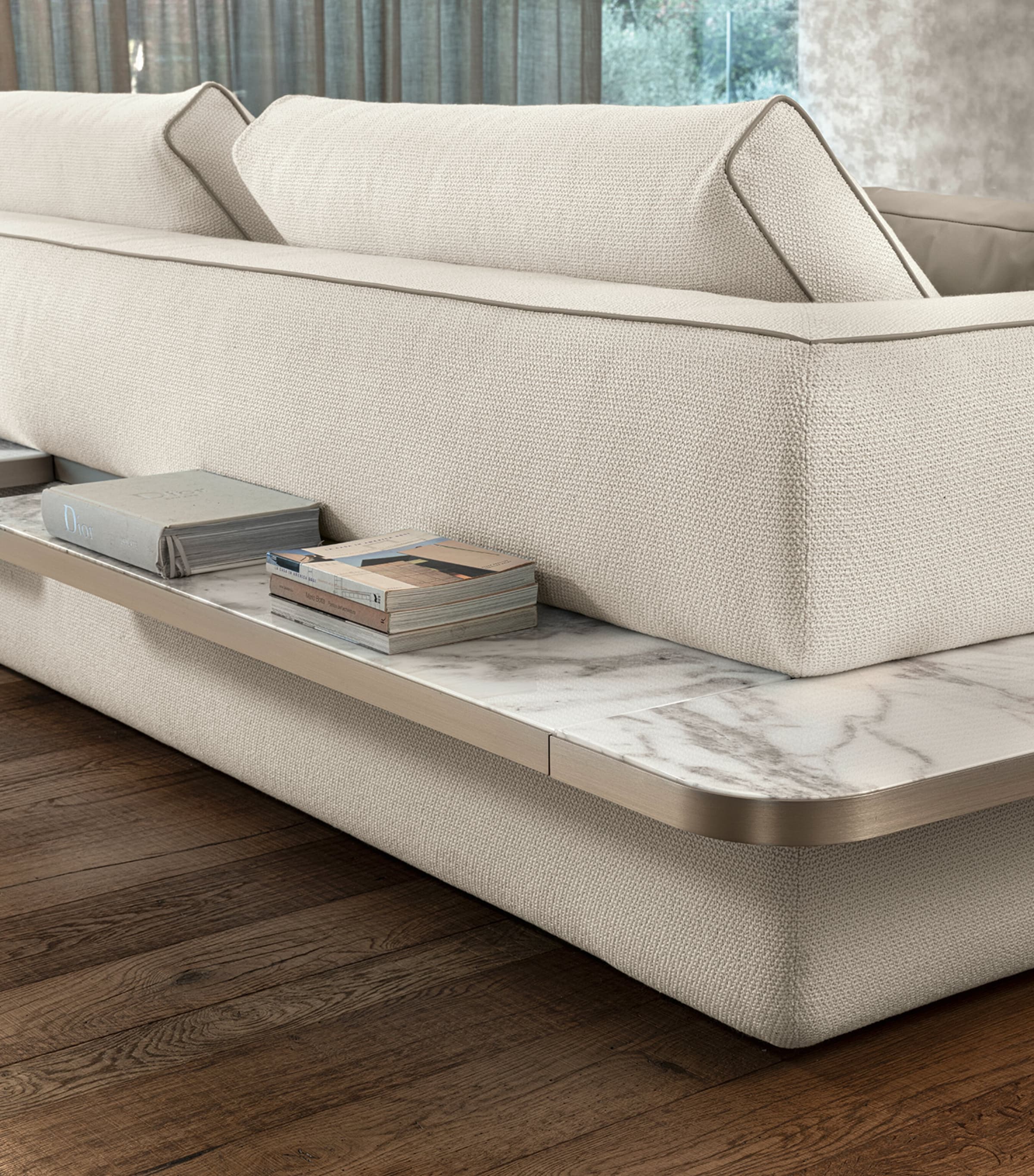 Close-up of the sofa arm and marble side table built-in, beige fabric.