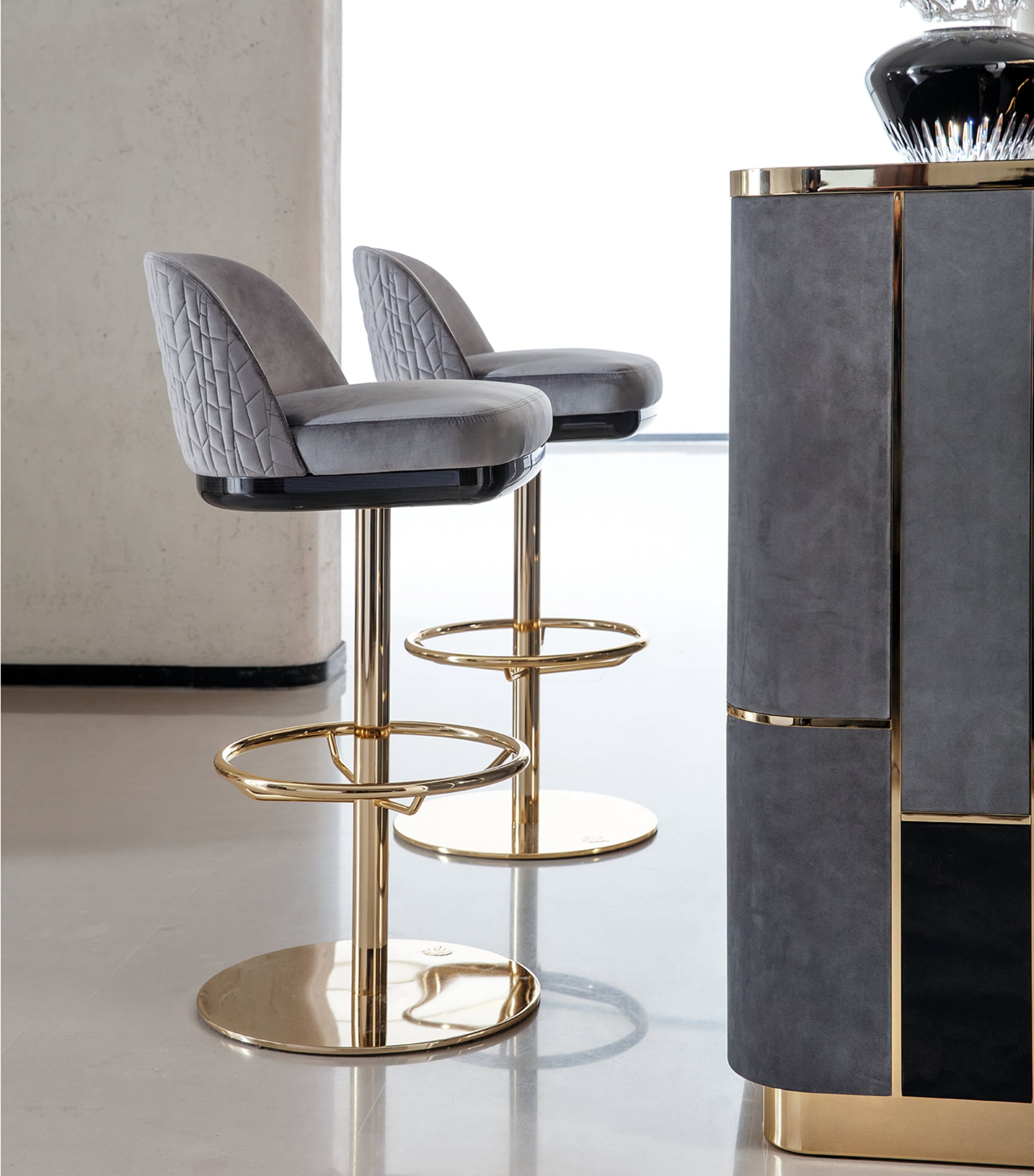 Close-up of bar stool and corner of Charisma bar with gold metal accents