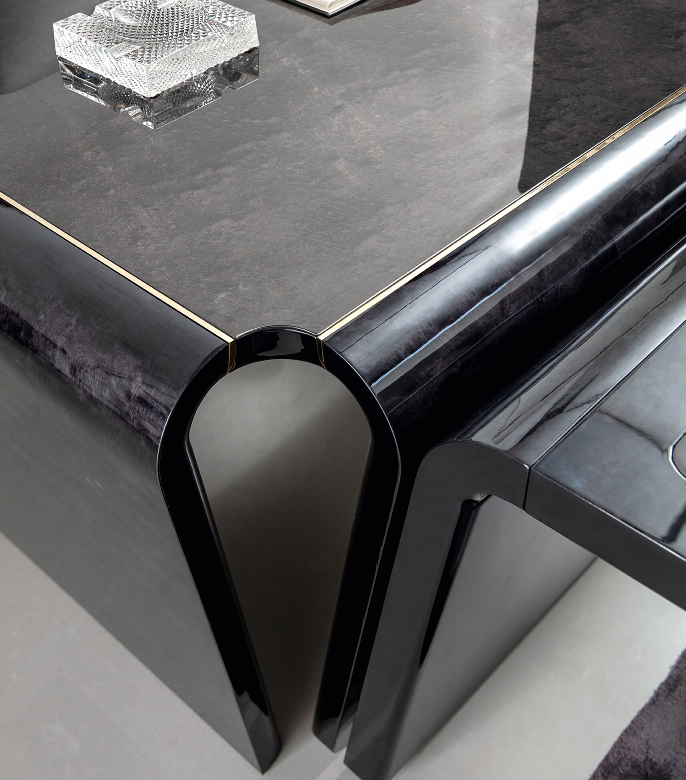 Close-up of desk corner showing glossy black finish and curved edge