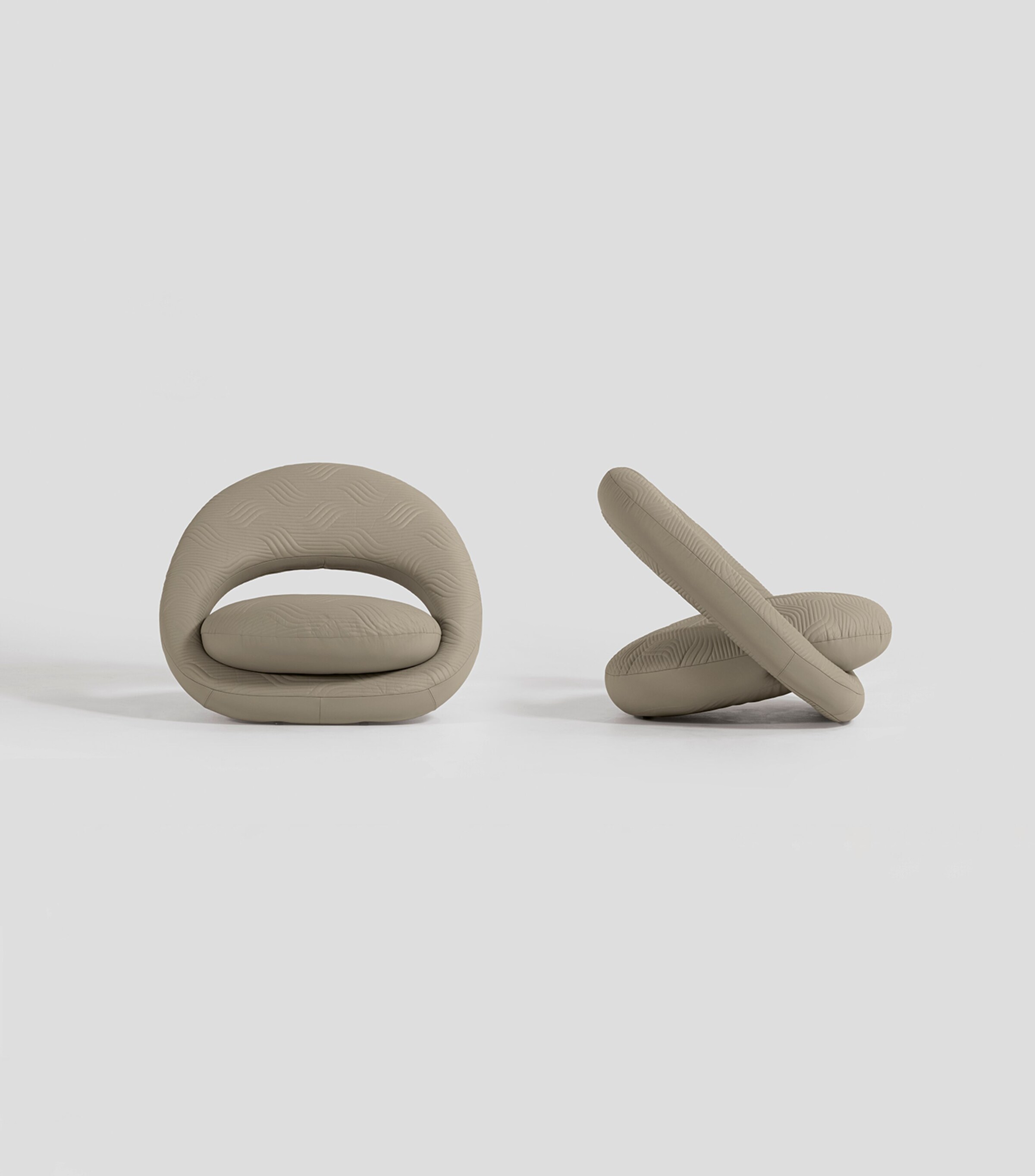 Two beige lounge chairs shown from side and front in a minimal setting